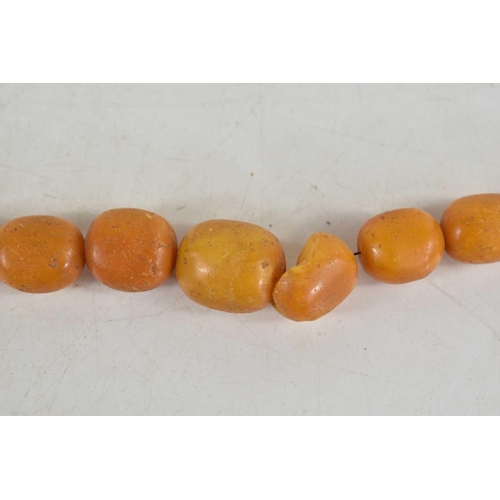 18 - A vintage butterscotch amber beaded necklace, composed of graduated beads on a wire string, 56g. one... 