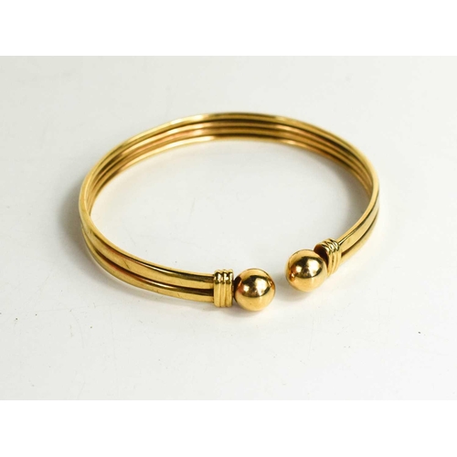 183 - A 9ct gold torc bracelet, with two reeded ferules and ball form ends, 9.88g.