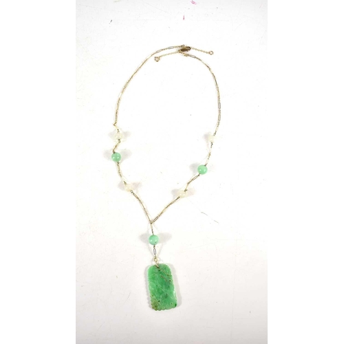 208 - A Chinese 9ct gold and jade necklace with a carved green jade pendant.