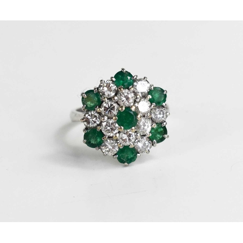 227 - An 18ct white gold, diamond and emerald cluster ring, composed of twelve brilliant cut diamonds, and... 