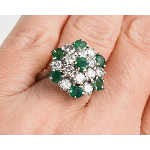 227 - An 18ct white gold, diamond and emerald cluster ring, composed of twelve brilliant cut diamonds, and... 