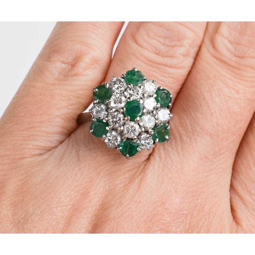 227 - An 18ct white gold, diamond and emerald cluster ring, composed of twelve brilliant cut diamonds, and... 