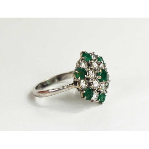 227 - An 18ct white gold, diamond and emerald cluster ring, composed of twelve brilliant cut diamonds, and... 