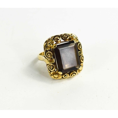 23 - A 9ct gold and smoky quartz ring, the rectangular cut quartz in a scroll and flower pierced setting,... 