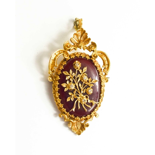 246 - A 9ct gold, diamond and carnelian pendant / brooch, the oval carnelian overlaid with a floral bouque... 