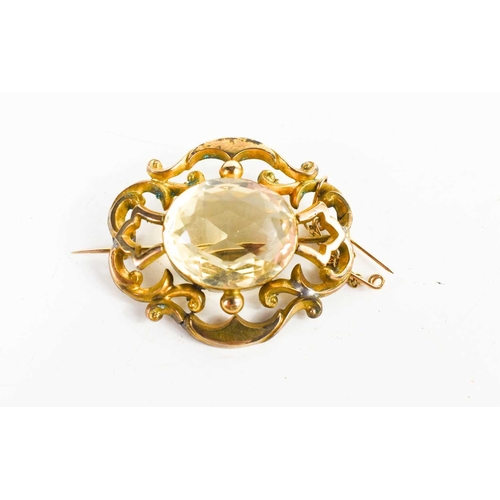 264 - A git metal Victorian pinchbeck and pale citrine brooch, with safety chain, the oval citrine set wit... 