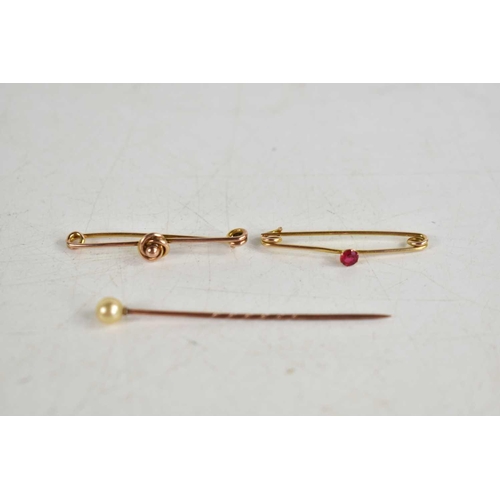 268 - Two 9ct gold pin brooches, one set with a pink stone, together with a 9ct gold and pearl stick pin, ... 