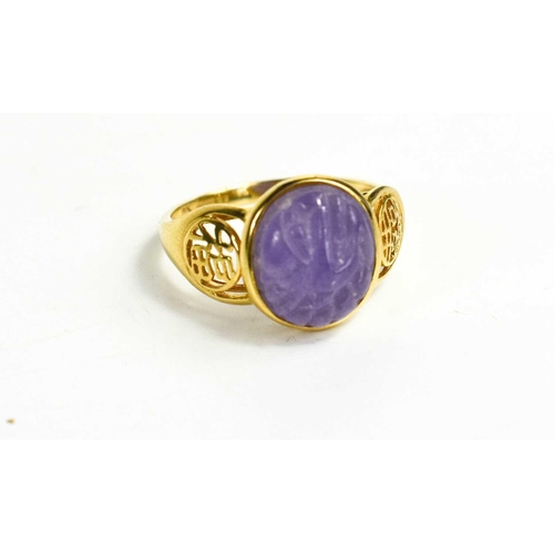 269 - A 14ct gold Chinese lilac jade ring, the oval carved jade between pierced shoulders, size N, 2.9g.