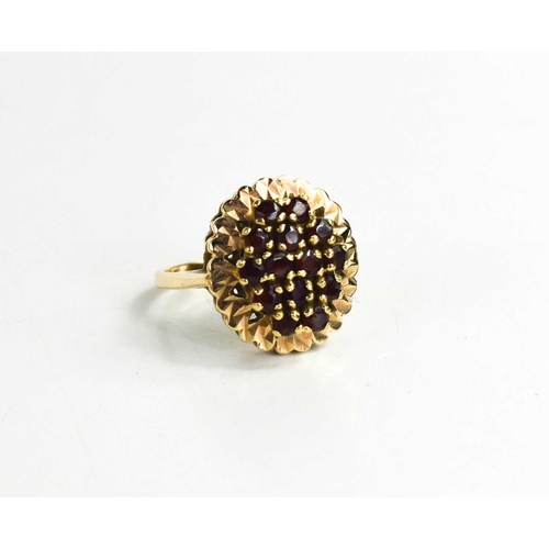 279 - A 9ct gold and garnet cluster ring, set in oval form with decorative border, size P/Q, 5.86g.