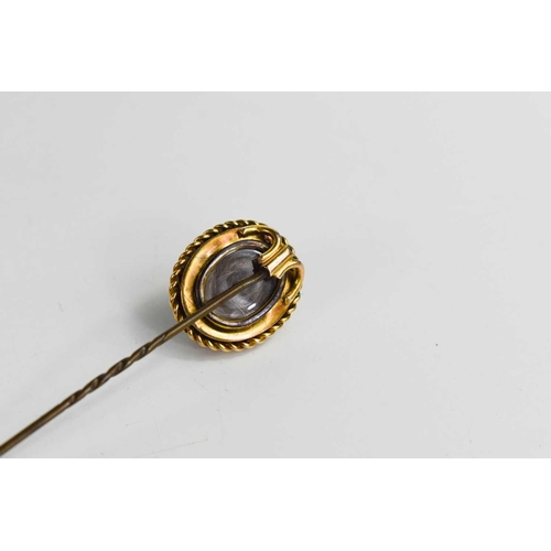 28 - A gold, garnet cabochon and old cut diamond pin, the garnet within a ropetwist border 2cm long, cent... 