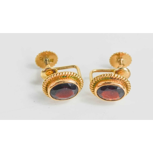 302 - A pair of 14ct gold and garnet earrings, the oval cut garnets in a ropetwist style border, with scre... 