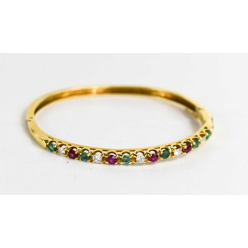 305 - An 18ct gold, diamond, emerald and pink sapphire bangle, fifteen brilliant cut stones in total, with... 