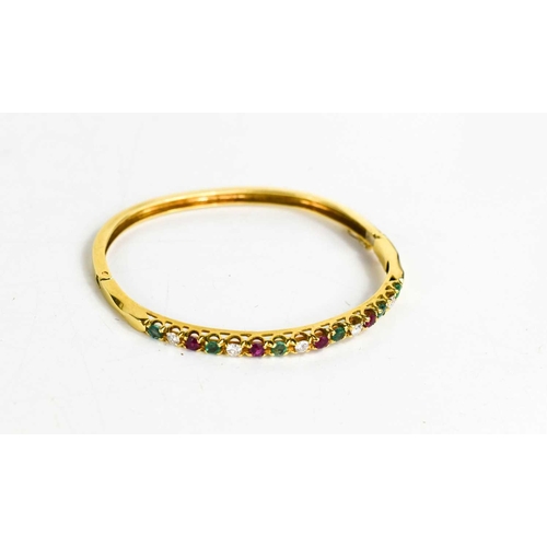 305 - An 18ct gold, diamond, emerald and pink sapphire bangle, fifteen brilliant cut stones in total, with... 