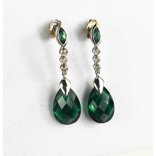 313 - A pair of 9ct white gold and tourmaline earrings, the pear drops suspended beneath three diamonds an... 