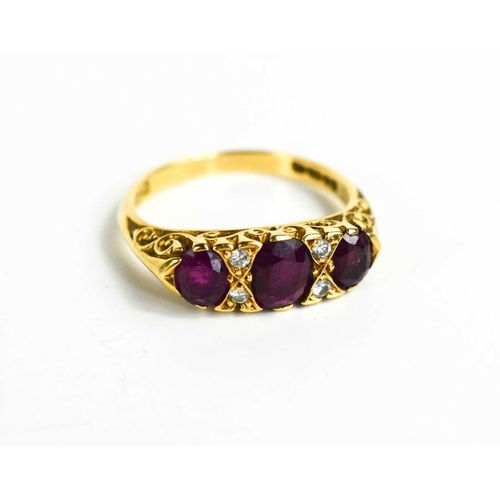 340 - An 18ct gold, ruby and diamond ring, the three oval cut rubies interspersed by two brilliant cut dia... 