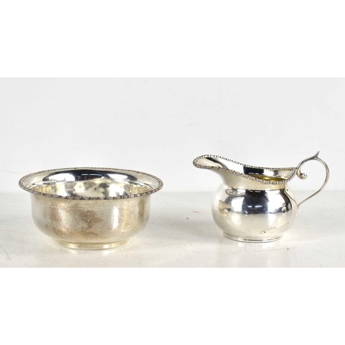 357 - A small silver cream hug of helmet form together with a small silver bowl, both hallmarked for Willi... 