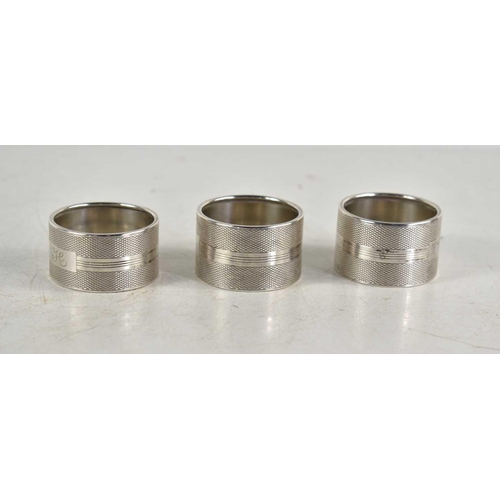 361 - A group of three matching silver napkin rings with machine turned decoration, hallmarked for W I Bro... 