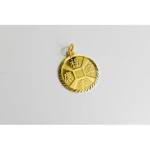 39 - A Chinese gold Feng Shui pendant, testing as at least 14ct gold, the disc form pendant bearing calli... 