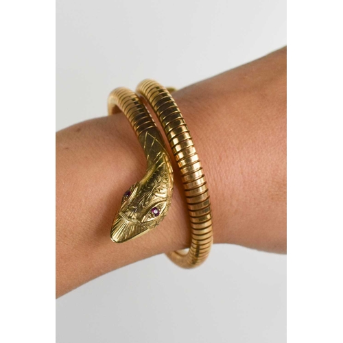 6 - A 9ct gold snake form bracelet, set with ruby eyes, and composed of articulated links terminating wi... 