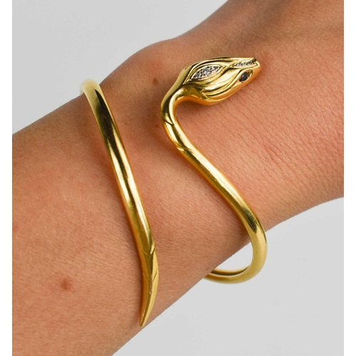 7 - A gold snake form bangle, the sake head set with six brilliant cut diamonds to the head, and sapphir... 