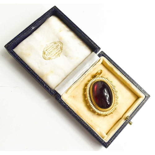 97 - A Victorian gold, garnet cabochon and enamel mourning pendant, the garnet with foil back with an int... 