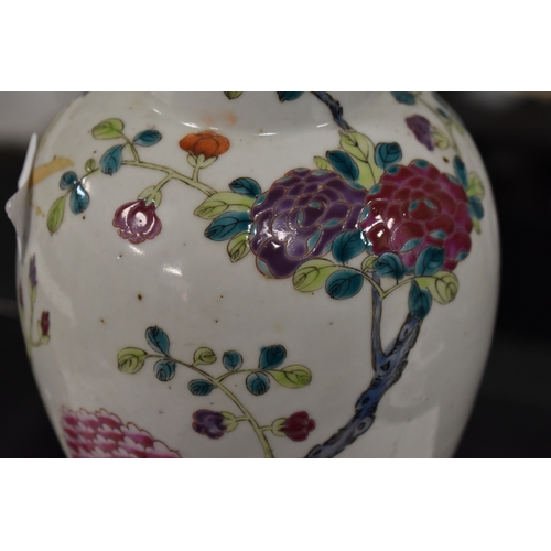 59 - A Chinese Famille Rose vase, Qing Dynasty, decorated with flowers and trees, the lid having a Foo do... 