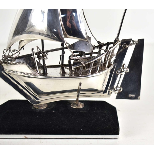 10 - A sterling silver model of a sailing boat on a stand, 19.5cm high, 4.9toz.