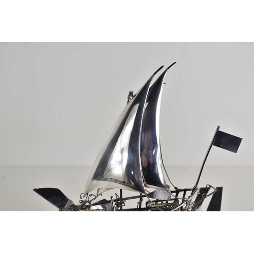 10 - A sterling silver model of a sailing boat on a stand, 19.5cm high, 4.9toz.