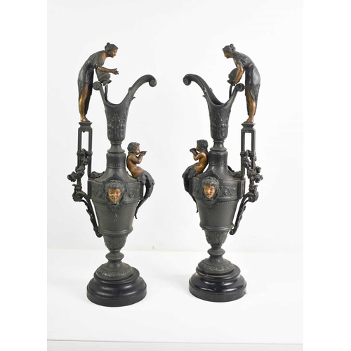 224 - A pair of Victorian pottery ewers, in matt black, the decorative handles in the form of classical st... 