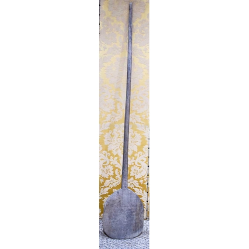 263 - An antique wooden dough / bread paddle, 215cm long.