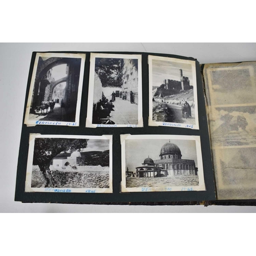 316 - A WWII photograph album containing photos of Jerusalem in 1945, a ship on fire at sea, HMS tracker, ... 