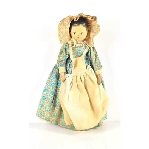 345 - An early 20th century wooden peg doll with jointed limbs and painted face, wearing a dress and bonne... 