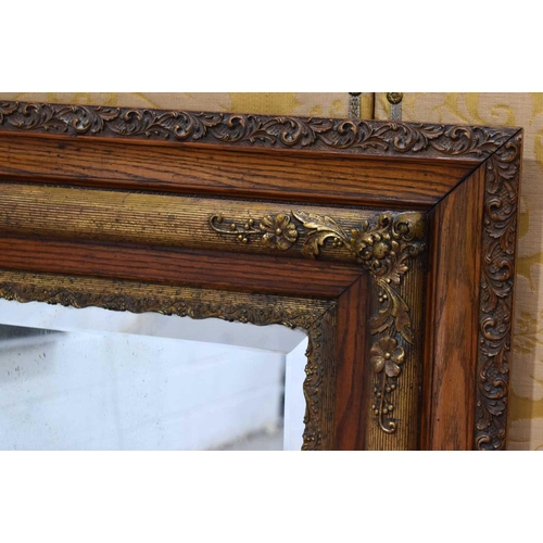 370 - A 19th century oak and gilt hall mirror, the border carved with foliate scrolls, 136.5cm by 80cm.