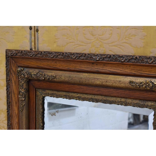 370 - A 19th century oak and gilt hall mirror, the border carved with foliate scrolls, 136.5cm by 80cm.