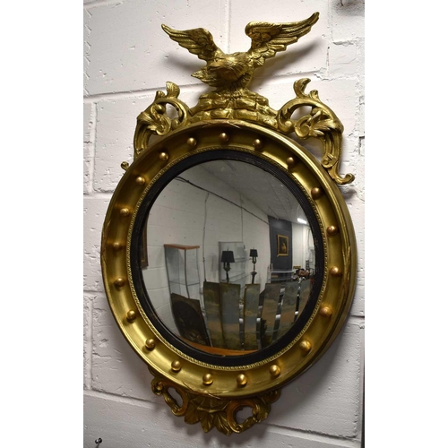 375 - A Regency-style convex giltwood mirror, the mirror within an ebonised reeded slip and gadrooned moul... 