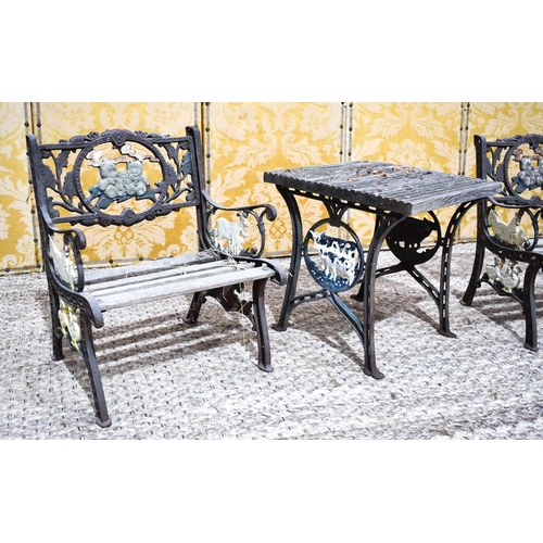 485 - A vintage cast iron child's table and two matching chairs, the two chairs having panels cast with te... 