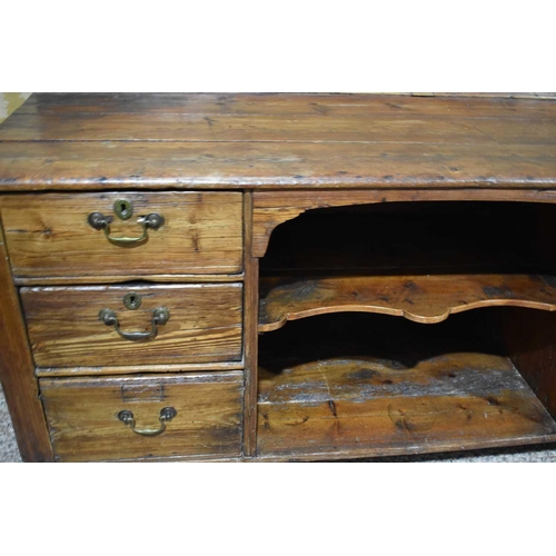 509 - A Georgian pine dresser base, with dog kennel flanked by three graduated drawers, 94 by 190 by 62cm.