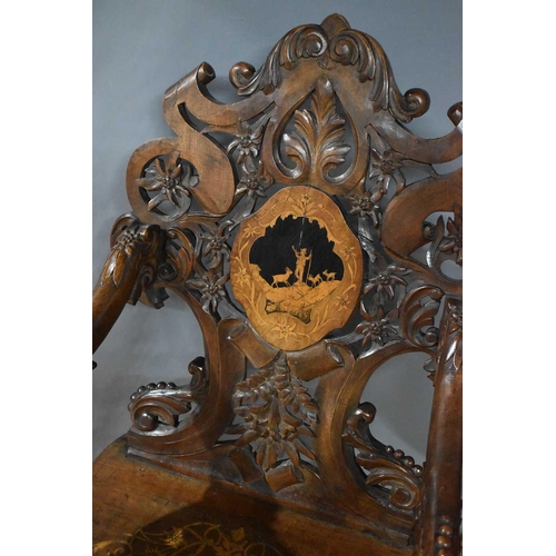 512 - A 19th century Blackforest 'musical' chair (lacking musical mechanism) the decoratively carved back ... 