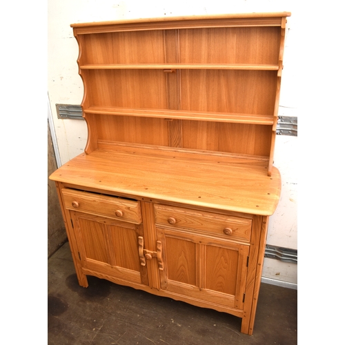 514 - An Ercol light elm sideboard and dresser, the base having two drawers over two twin panel cupboards,... 