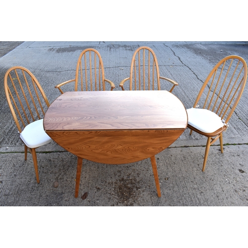 515 - An Ercol elm and beech drop leaf dining table together with four Ercol style chairs.