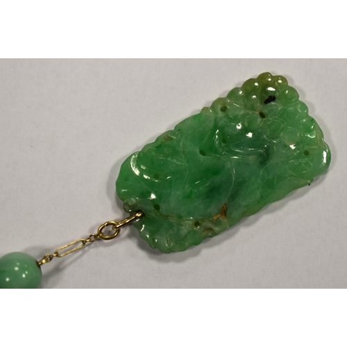 208 - A Chinese 9ct gold and jade necklace with a carved green jade pendant.