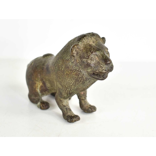 260 - An early bronze lion, with areas of green patination, incised with details to the face and fur, 8cm ... 