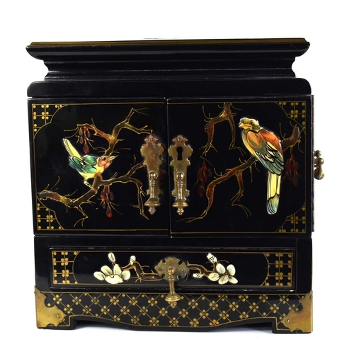 248a - A Chinese black lacquered two door cabinet opening to reveal two drawers with painted and applied de... 