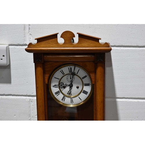 331 - An oak cased Vienna wall clock, white enamel dial with Roman numerals.