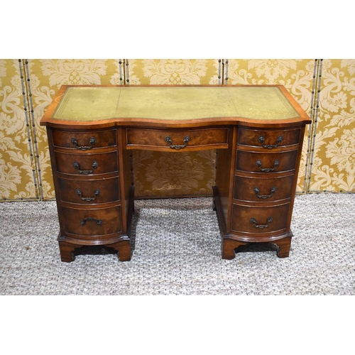 399 - A 20th century desk, with shaped front, two banks of drawers flanking a kneehole, green leather top ... 