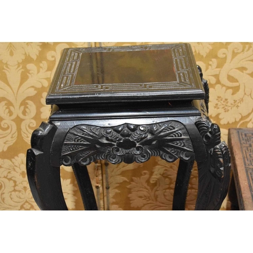 406 - An early 20th century Chinese ebonised jardiniere stand, the shaped aprons carved with face masks ra... 