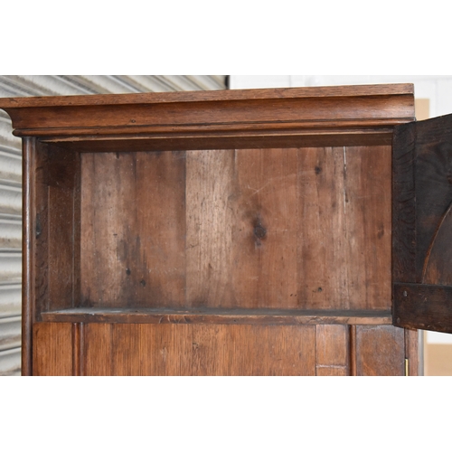 400 - A Victorian oak cabinet of slender proportions, the long panelled door in two sections revealing an ... 