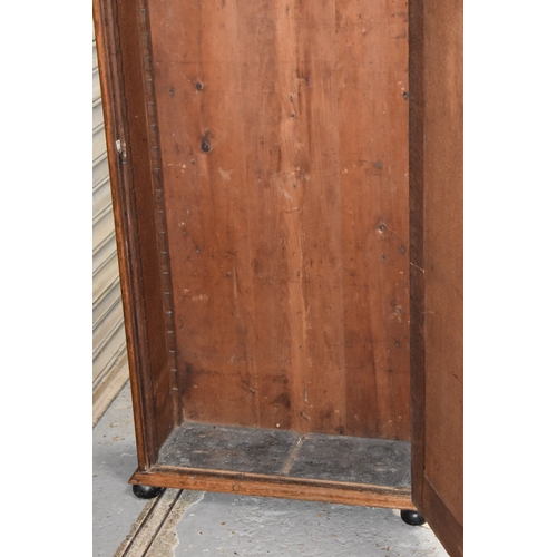 400 - A Victorian oak cabinet of slender proportions, the long panelled door in two sections revealing an ... 