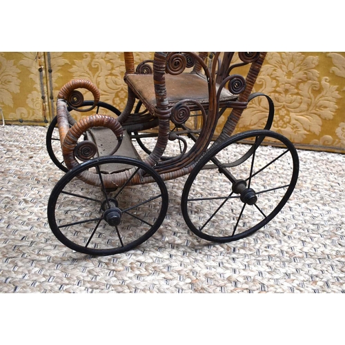 112 - A late Victorian/early Edwardian child's wooden and cane dolls push chair with foot rest, metal unde... 