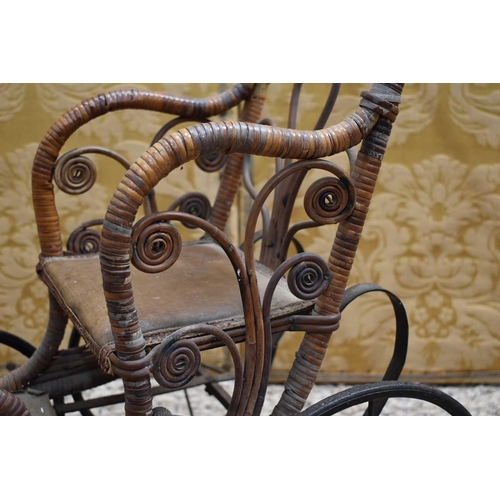 112 - A late Victorian/early Edwardian child's wooden and cane dolls push chair with foot rest, metal unde... 